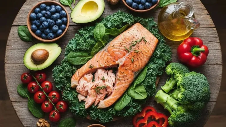 Anti-inflammatory foods arranged on a wooden table with salmon, avocado, berries, and leafy greens for healthy weight loss.