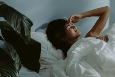 person lying down at night, awake and stressed